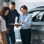 young-couple-talking-sales-person-car-showroom1.jpg