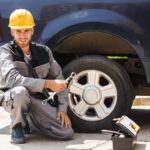 young-smiling-mechanic-work-clothes-yellow-hardhat-happily-looking-camera-holding-wrench-changing-car-wheel-outdoor_574295-1615.jpeg