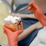 model-tooth-dentist-doctor-shows-patient-tooth-reception-dentist-s-office-min-scaled.jpg