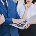 business-people-holding-laptop-ezgif.com-jpg-to-webp-converter.webp