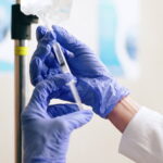 healthcare-iv-drip-and-hands-of-nurse-with-syringe-for-medicine-infusion-and-medication-dose-1.jpg