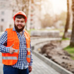 portrait-brutal-beard-worker-man-suit-construction-worker-safety-orange-helmet-against-pavement-shows-thumb.jpg